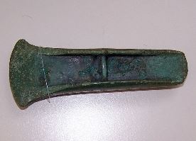 RANDBIJL MET DWARSRIBBE Objectnr. WA 1173. Randbijl met dwarsribbe, gegoten in een mal. Afmetingen lengte 12,9 cm., breedte 4,9 cm, dikte 2,4 cm. Dateert uit Midden Bronstijd, ca. 1600 v.Chr. Opgespoord met metaaldetector in de Wageningse Eng door Hans Roelofs. Aangekocht door Ver. Vrienden van De Casteelse Poort. 